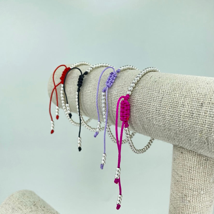 Pulsera de Bolitas de Plata sobre un Hilo de Color.