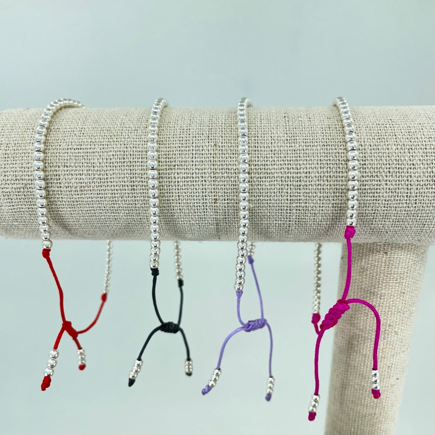 Pulsera de Bolitas de Plata sobre un Hilo de Color.