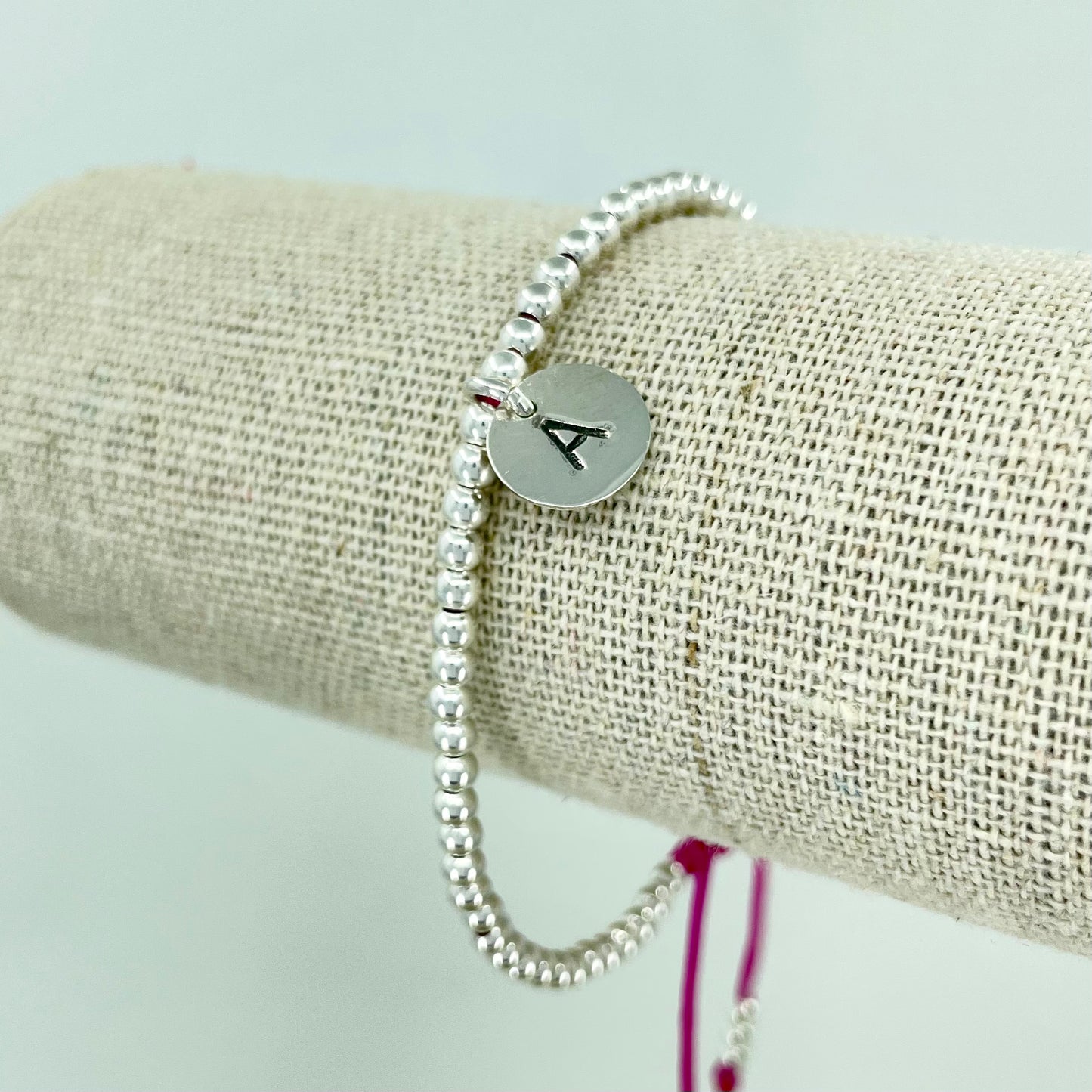 Pulsera de Bolitas de Plata sobre un Hilo de Color.